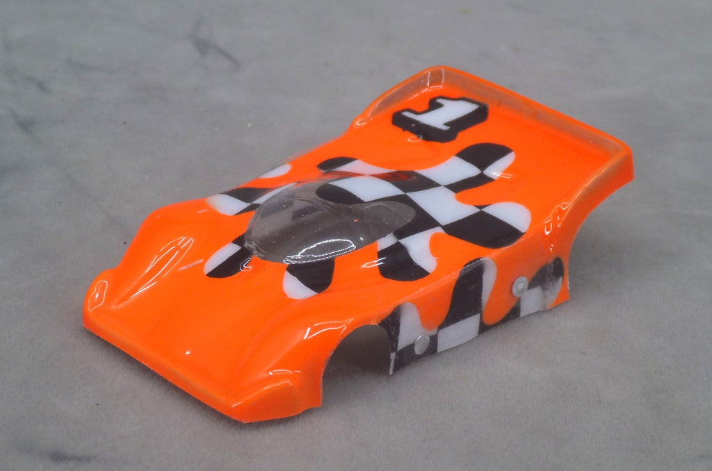 Front three-quarter view of orange Checkerboard Blob painted Lexan HO slot car body with flowing black and white checkerboard panels