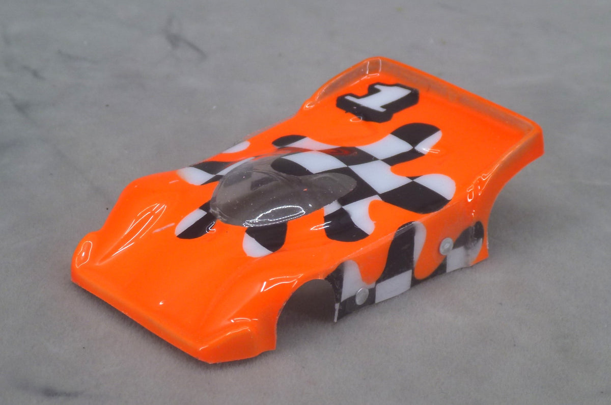 Front three-quarter view of orange Checkerboard Blob painted Lexan HO slot car body with flowing black and white checkerboard panels
