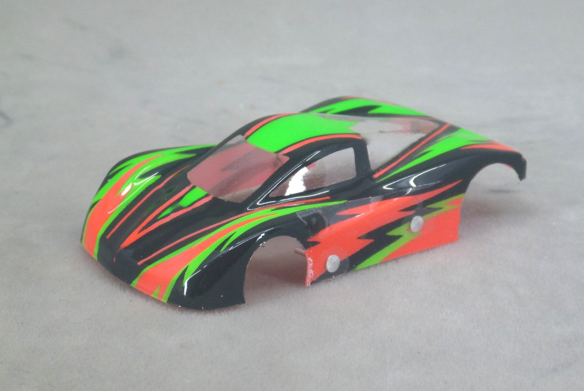 Front three-quarter view of black Dazzle painted Lexan HO slot car body with red and green jagged graphics and red pinstripes