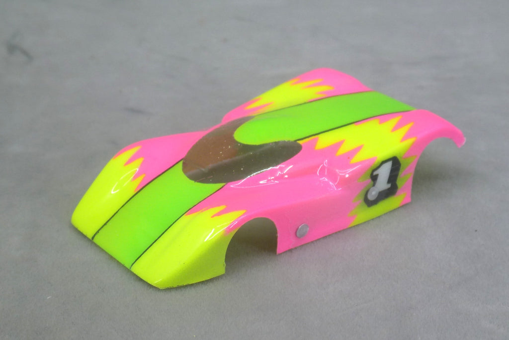 Front three-quarter view of lime green, yellow and fuchsia Neon Sawtooth painted Lexan HO slot car body with number 1 on the side