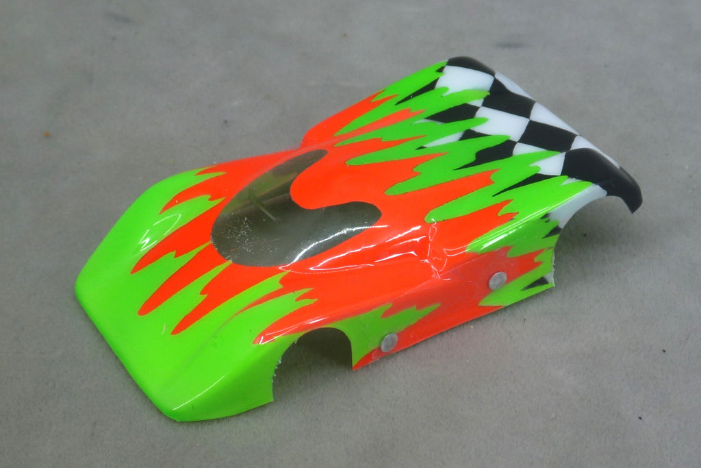 Front three-quarter view of green and orange Checkered Surge painted Lexan HO slot car body with checkerboard tail