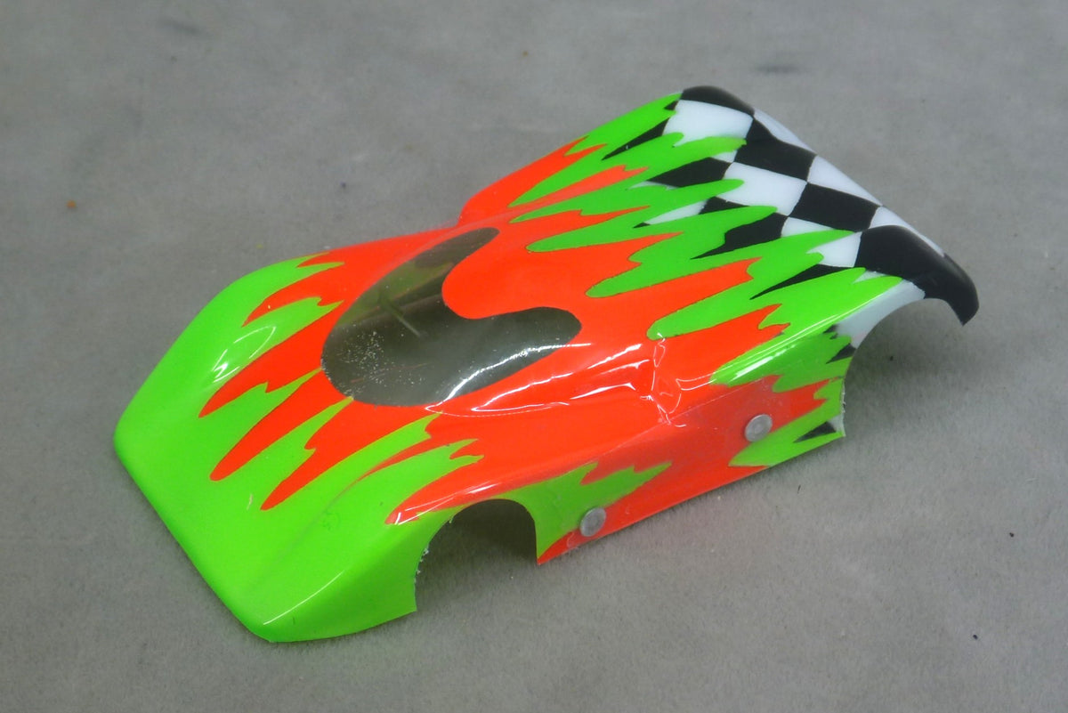 Front three-quarter view of green and orange Checkered Surge painted Lexan HO slot car body with checkerboard tail