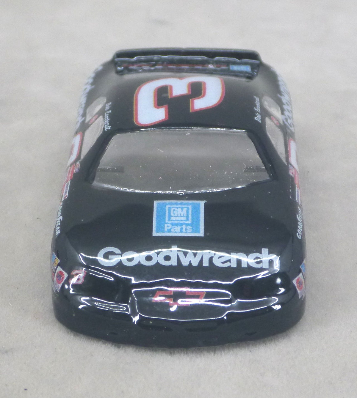 A black lexan model race car with 'Goodwrench' and a GM Parts logo on the hood, featuring the number 3 on the roof.