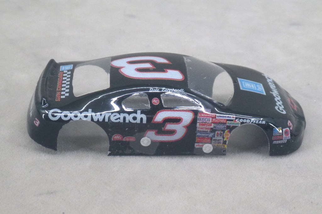 A black lexan plastic body shell for a die-cast toy race car, featuring the number 3 in red and white, with Goodwrench and Goodyear branding, shown on a light gray textured background.