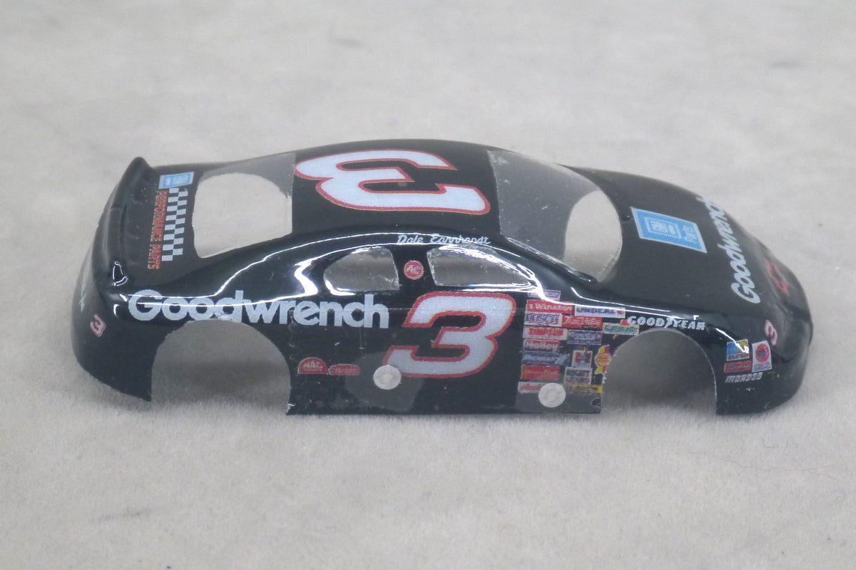 A black lexan plastic body shell for a die-cast toy race car, featuring the number 3 in red and white, with Goodwrench and Goodyear branding, shown on a light gray textured background.