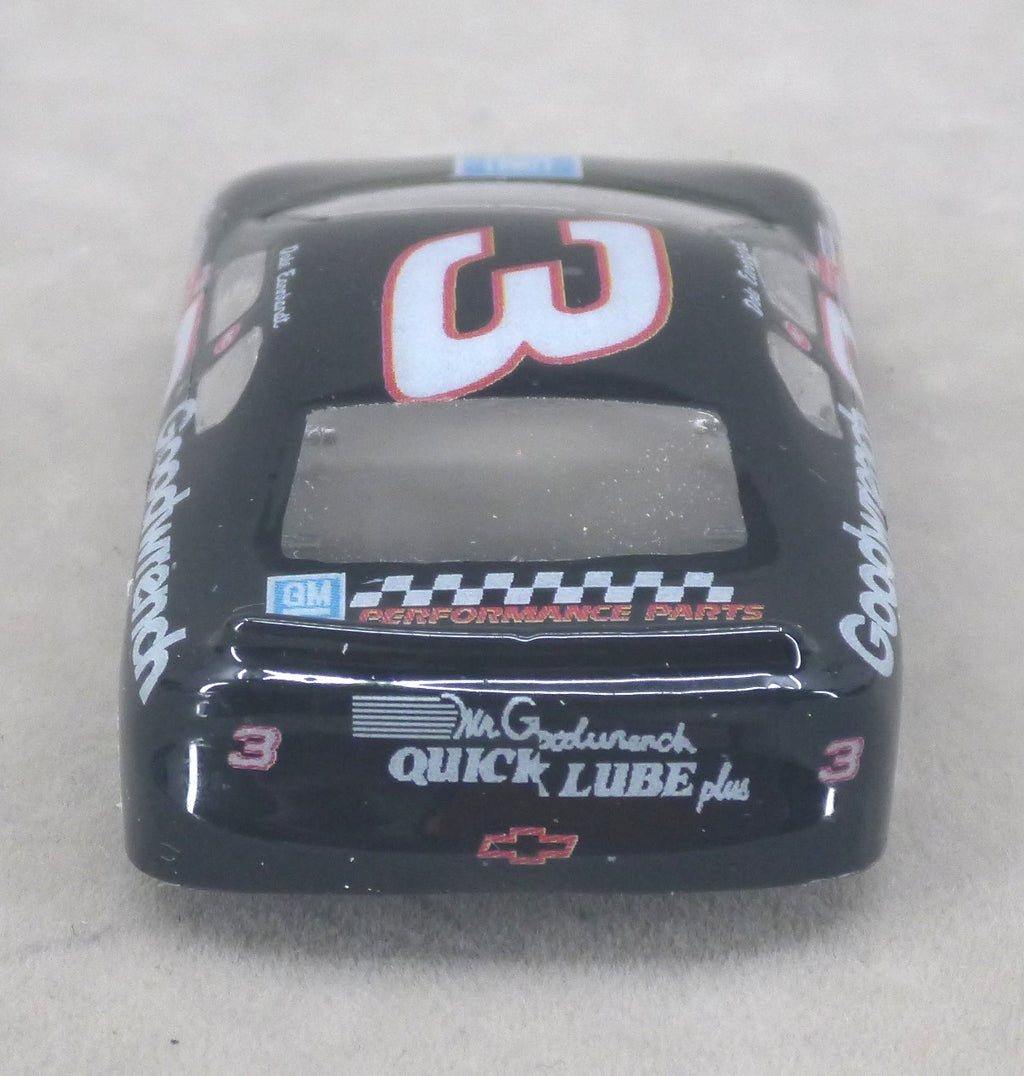 A black lexan model race car body shell featuring the number 3 and sponsor decals including Goodwrench, GM Performance Parts, and Mr. G's Quick Lube, photographed on a neutral gray background.