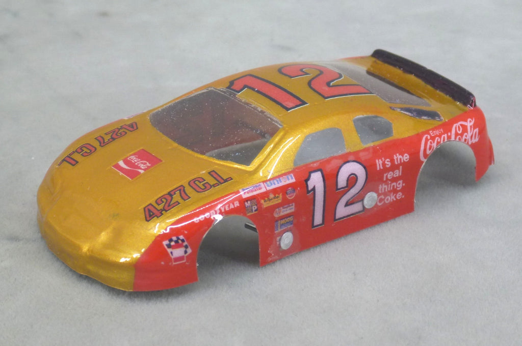 Front three-quarter view of red and gold Coca-Cola #12 painted Lexan HO slot car body