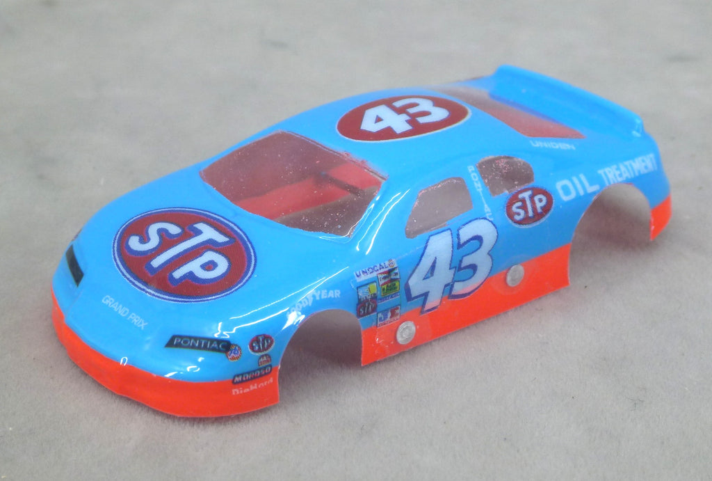 Front three-quarter view of blue STP #43 painted Lexan HO slot car body with red lower trim