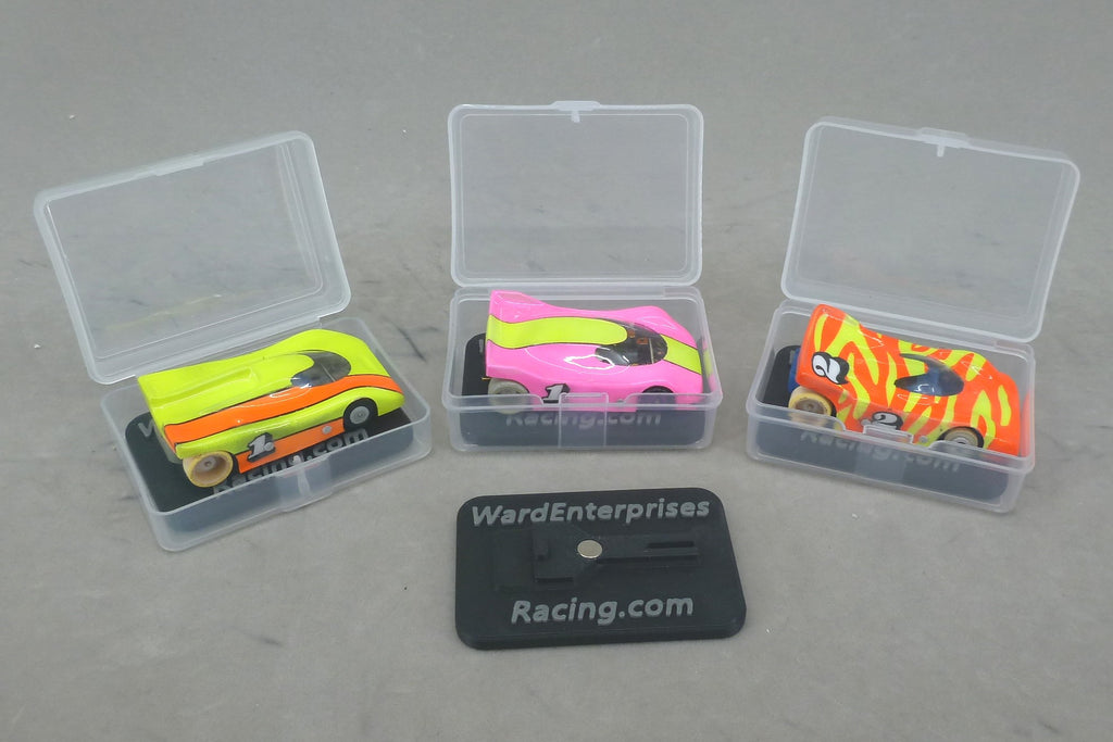 Open clear HO slot car cases with painted cars on magnetic chassis stands, Ward Enterprises Racing branding
