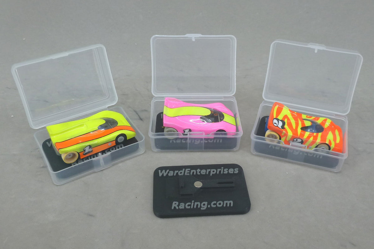 Open clear HO slot car cases with painted cars on magnetic chassis stands, Ward Enterprises Racing branding